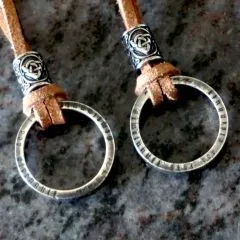 Schmuckstück als Statement – getragen um den Hals, kombiniert mit lässigem Outfit für Herren und Damen.